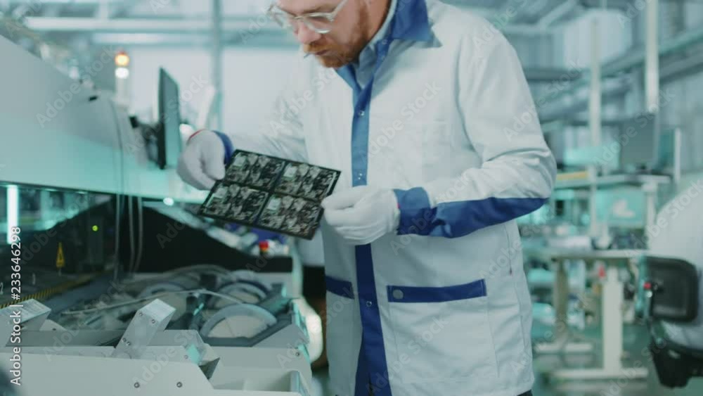 Aufkleber high-tech factory: quality control inspector picks up electronic printed circuit board and checks it