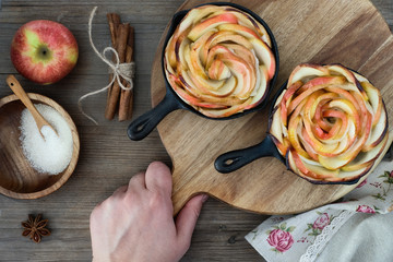 Homemade puff pastry with rose shaped apple slices baked in iron skillets