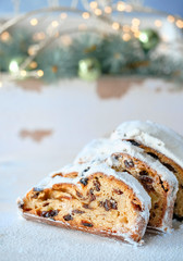 Christmas stollen on white festive background with fir twigs and trinkets
