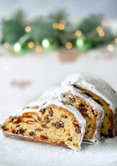 Christmas stollen on white festive background with fir twigs and trinkets