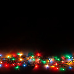 Christmas background with lights and free text space. Christmas lights border. Glowing colorful...