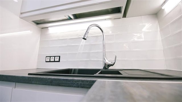 flowing water from a modern chromed faucet in the kitchen in the shower mode. Saving natural resources.