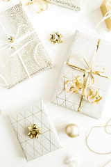 Golden gift boxes, decorations on white background. Flat lay, top view Christmas, New Year holiday gifts packaging concept.