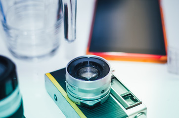 analog camera with exposed instant films and drotty headphones on a bamboo table