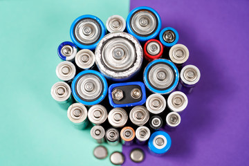 Ecology recycling concept. Many different types used or new battery, rechargeable accumulator, alkaline batteries on color background. Nature energy
