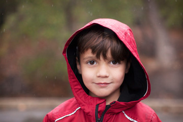 Portrait of smiling boy in rain outdoors © Cavan for Adobe
