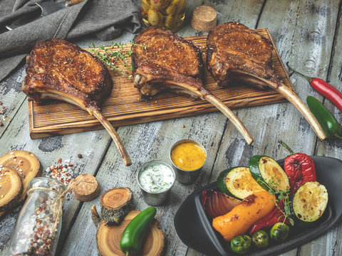 Grilled lamb,mutton meat chops with vegetables on a serving board. Rustic food concept