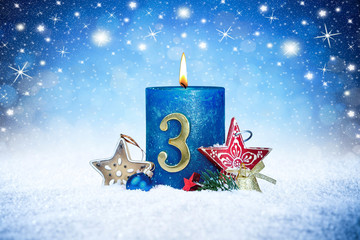 third sunday of advent blue candle with golden metal number red decoration one on wooden planks in...