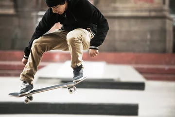 Fotobehang Skateboard Full length of man performing skateboard stunt at skateboard park  © Cavan for Adobe