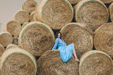 Beautiful woman in a dress on haystacks.