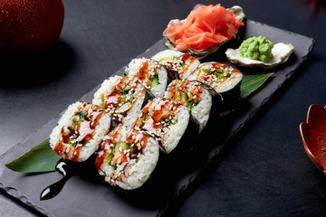 Fresh rolls in nori seaweed with avocado, pickled ginger and soy sauce. Asian cuisine, traditional dish - sushi.