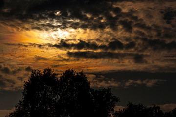 Obraz na płótnie Canvas Cloudy black and orange sky during sunset - Photography