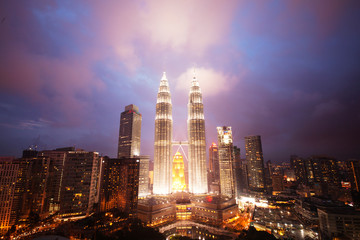 Fototapeta premium Illuminated PETRONAS Towers against dramatic sky