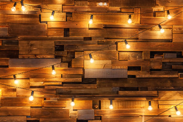 Modern dark classical style interior design apartment with retro lamps hanging light bulbs background. Wooden planks with lamps. Decorated interior room with gold lights. Copy space mockup poster