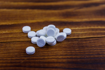 Fototapeta na wymiar Pile of pills on the wooden background