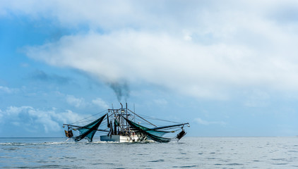 Obraz premium A Shrimp Boat Trawler Heading to Sea for a Day of Fishing in Savannah Georgia