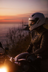 Man looking away while sitting on motorcycle by sea © Cavan for Adobe