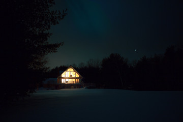 Illuminated house on snow covered field at night © Cavan for Adobe