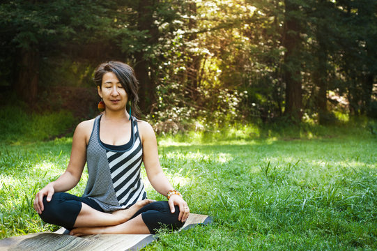 Woman mediating on grassy field