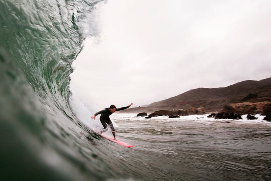 Man surfboarding on splashing wave in sea