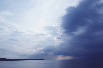 Dramatic beautiful evening sky with huge clouds over calm sea horizon 