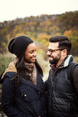 Fototapeta premium Happy couple looking at each other while standing in forest