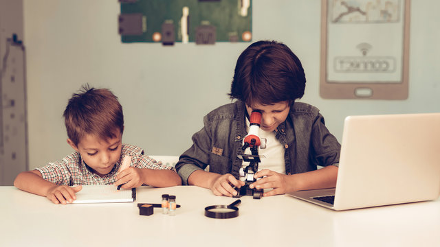 Sitting Boys Using Laptop and Microscope at Home. - Powered by Adobe
