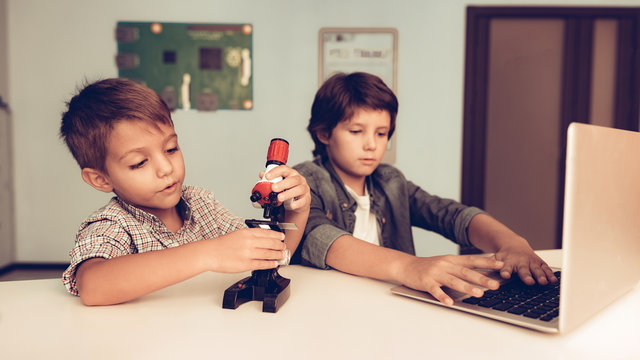 Sitting Boys Using Laptop and Microscope at Home. - Powered by Adobe