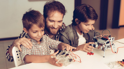 Bearded Father and Sons Constructing Robot at Home