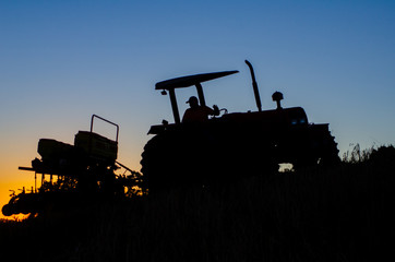 Trator plantando no pôr do sol 