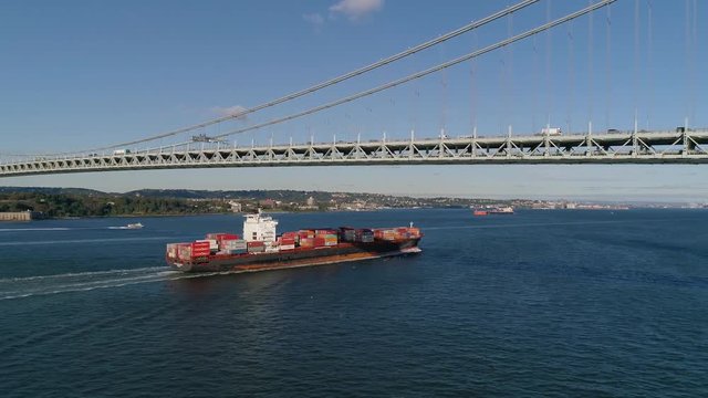 Aerial Dolly Shot of Freighter Passing under Verrazzano Bridge in New York City