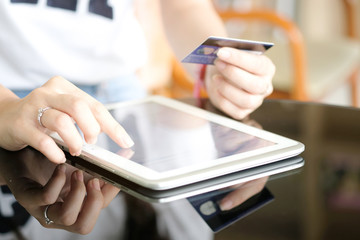 women modern lifestyle she sat in the living room on sofa , using his tablet pc and holding credit card her online To buy product in the internet