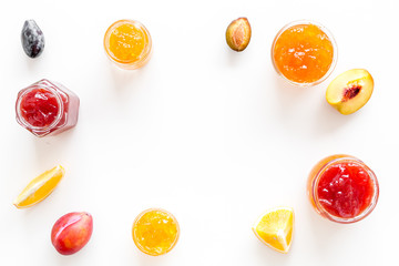 Jams different tastes made of fruits and berries near pieces of fruits on white background top view space for text