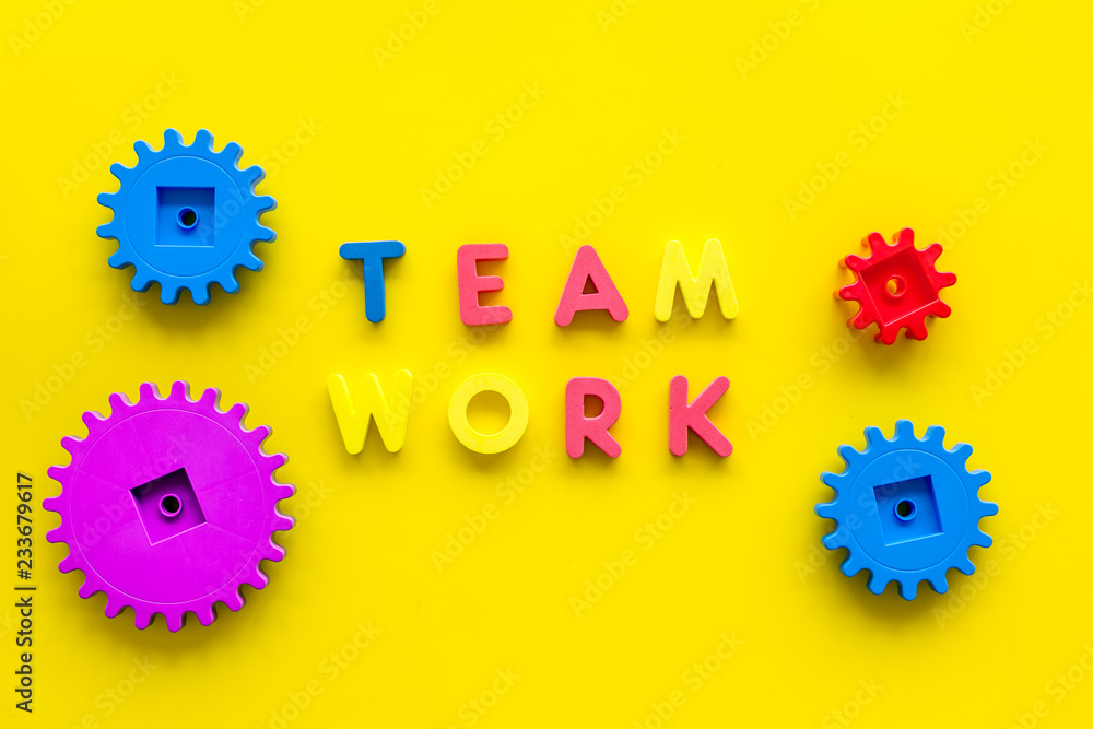 Poster teamwork concept. text teamwork lined with colored letters near toy gears on yellow background top v