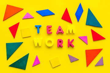 Teamwork concept. Teamwork techniques for students. Text teamwork lined with colored letters in abstract colored frame on yellow background top view