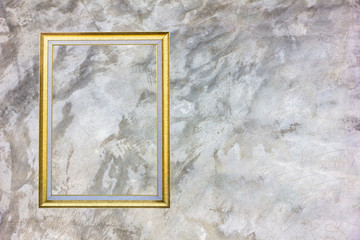 Old antique gold frame on grey stain concrete wall with stain for background.