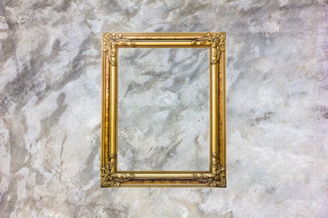 Old antique gold frame on grey stain concrete wall with stain for background.