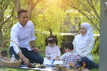 muslim malay family enjoying picnic at the park