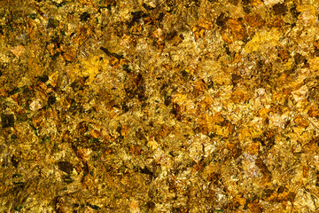 Shiny yellow gold leaf or scraps of gold foil background texture, surface from Back of Buddha image.