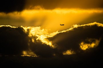 夕暮れ雲と横切る旅客機の影