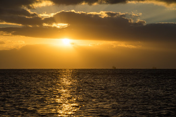 雲の間から、海を照らす朝日