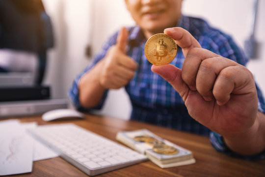 Business concept image; Man holding in hand symbol of crypto currency ;Cryptocurrency golden bitcoin