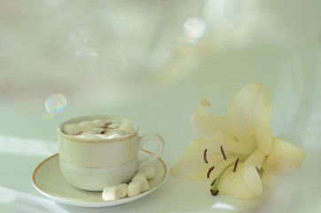 a Cup of coffee with a flower on the table with sunlight
