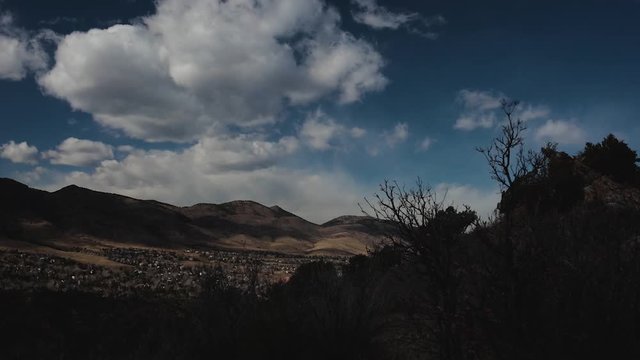 clouds and sunshine moving across Ken Caryl Valley and Dakota Hogback, Littleton, Colorado with rocky mountains in background highlighting dakota hogback