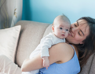 Beautiful happy young brunette woman with newborn baby on her hands, family happiness, love and care concept, mother day,