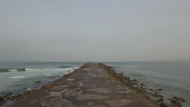 Shot over a seawall path passing by some fisherman's in Costa de Caparica, Almada, Lisbon. Shot by drone in Portugal