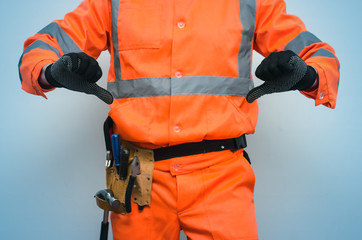 Disgruntled builder worker is showing a thumbs down isolated on blue background. Bad job concept.