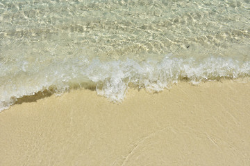 Clear sea water waves rushing to the soft fine sand beach. Close up of beach waves on of Lipe island,southern Thailand.