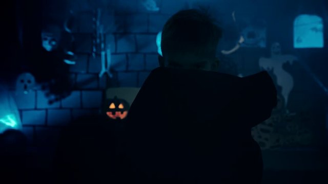 Young boy in a vampire costume for Halloween showing his scary face and teeth to camera