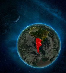 Argentina from space on Earth at night surrounded by space with Moon and Milky Way. Detailed planet with city lights and clouds.